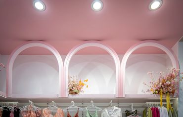 Soft pink tones, curved arches and floral displays.