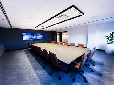 Boardroom chairs and table with feature acoustic paneling and wall mounted TV.
