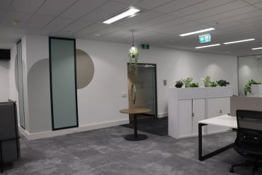 Sign in table within office setting including feature wall graphics and office storage.
