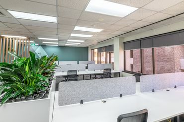 Sign in table within office setting including feature wall graphics and ottoman seat.