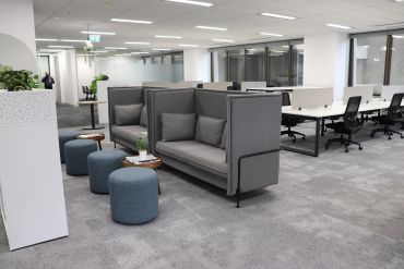Collaboration zone within office Fitout showcasing high back lounge chairs and ottomans.
