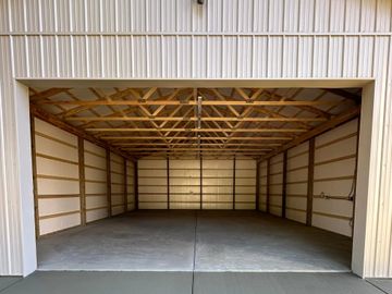 Empty garage with wooden beams and concrete floor.