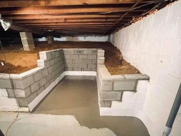 New concrete and block foundation walls in a basement waterproofing project.