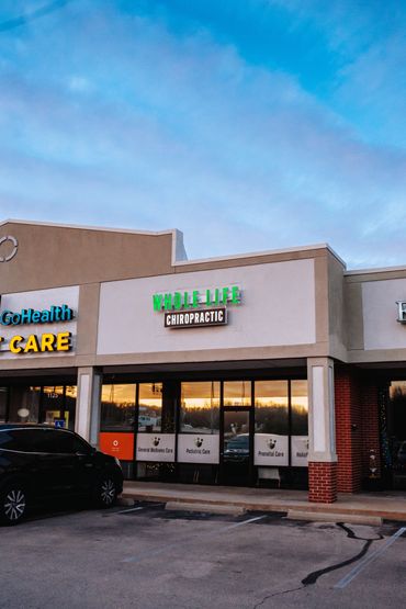 Whole Life Chiropractic clinic in a shopping center at sunset.