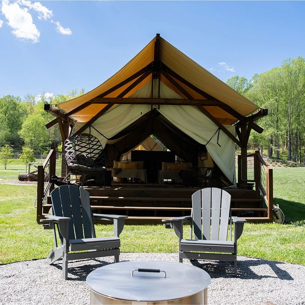 Glamping tent with outdoor seating under a clear sky.
