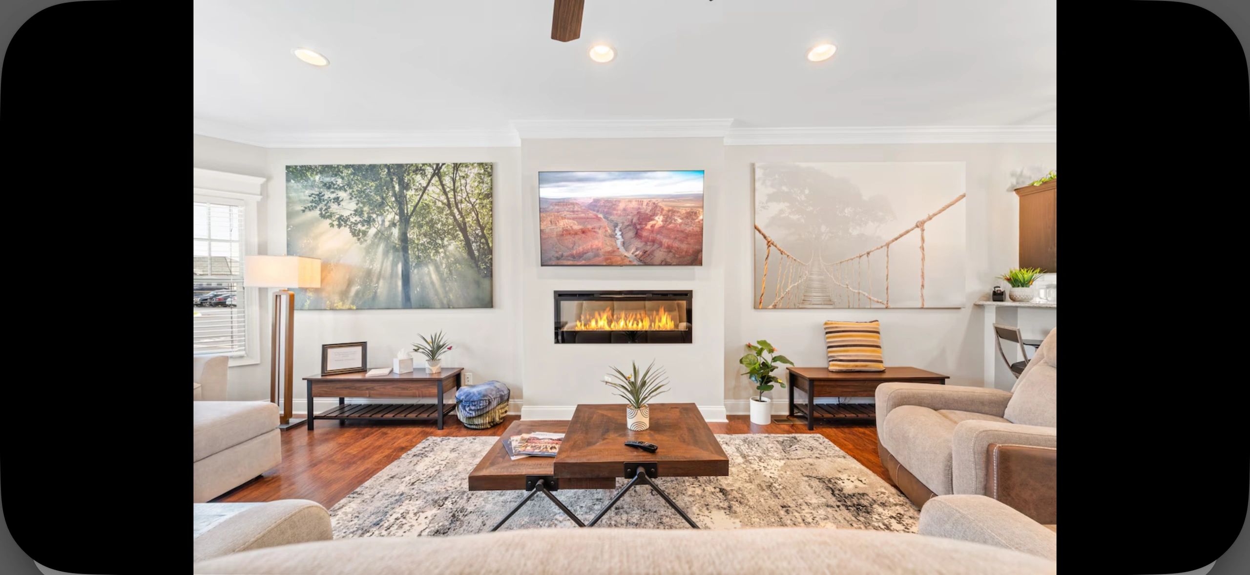 Cozy living room with modern fireplace and nature-themed artwork.