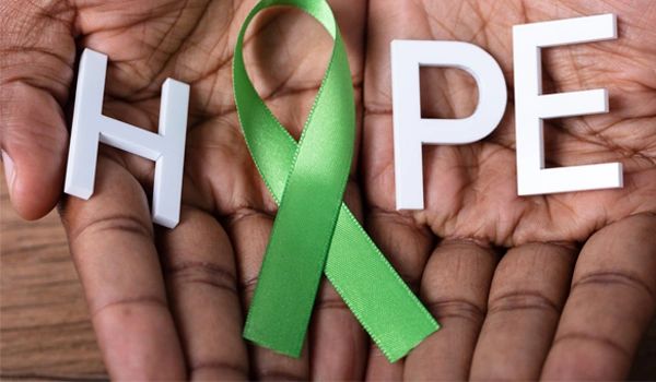 two hands coming together and open holding a green ribbon, replacing the 'o' within the word "HOPE"