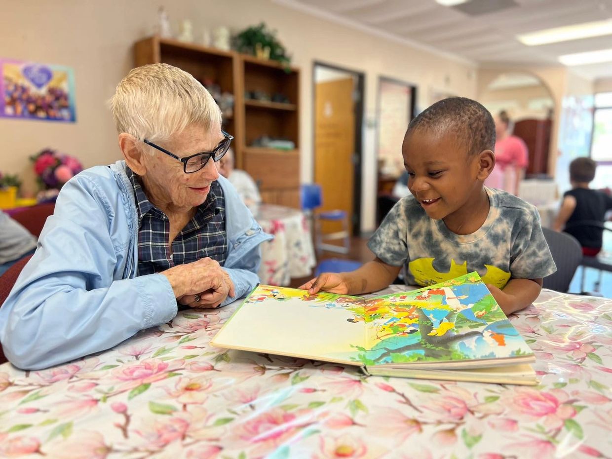 A senior grandparent reads together with a young child as they enjoy each other's company