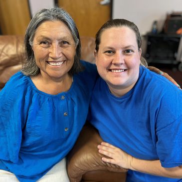 Staff member & elder smile together for a picture while at Gentog Senior Daycare in Tigard, Oregon