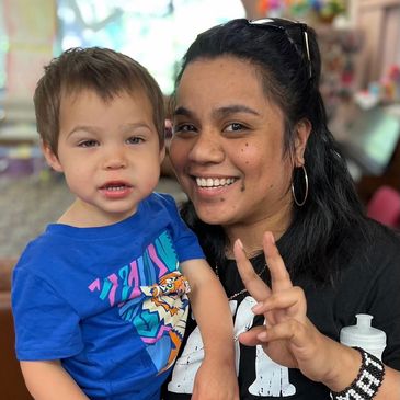 A staff member and child smile together for a picture while at Gentog Daycare in Tigard, Oregon