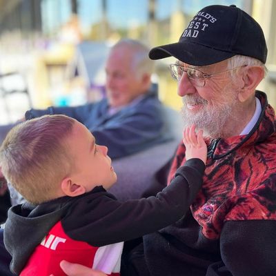 A child touches an elder's beard as they enjoy time at an intergenerational daycare in Tigard, OR
