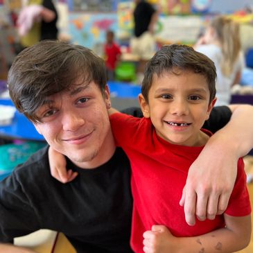 A staff member and child smile together for a picture while at Gentog Daycare in Tigard, Oregon