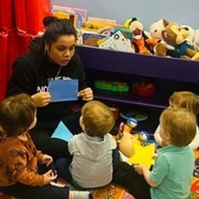 Children enjoy reading time w/ their teacher at Gentog Intergenerational Daycare