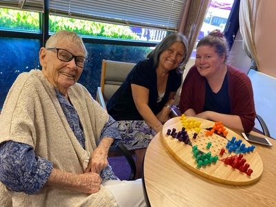 Elders and a caregiver enjoy time together with a game at Gentog Adult Day Center in Tigard, OR