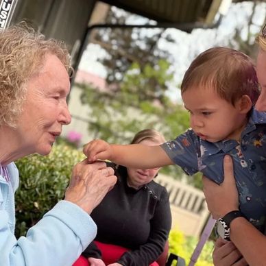 A Baby and a senior joyfully engage together at Gentog Intergenerational Daycare in Tigard, OR