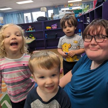 Childcare director and children smile together at Gentog Intergenerational Daycare in Tigard, OR