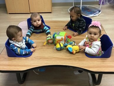Babies joyfully engage in lunchtime together at Gentog Intergenerational Daycare in Tigard, OR