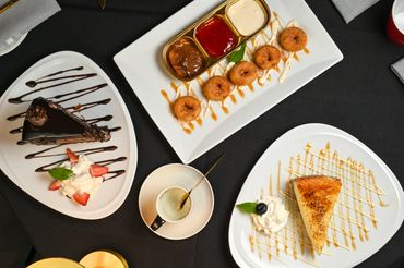 Italian dessert platter featuring chocolate cake, zeppole, and cheesecake at Mangia E Bevi