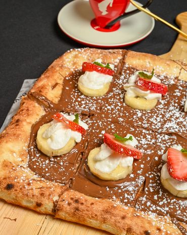 Nutella dessert pizza topped with fresh bananas and strawberries at Mangia E Bevi