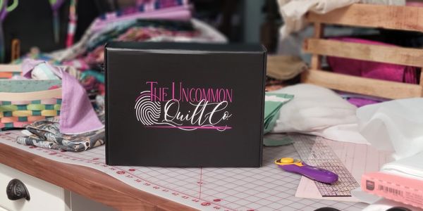Custom Gift Box on a worktable with cutting mat, rotary cutter, rulers, and fabric.