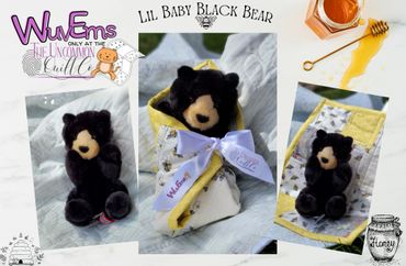 Black Bear swaddled in honeybee quilt.