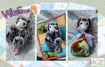 Plush possum swaddled in quilt.