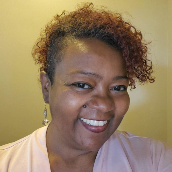 Smiling woman with curly hair and dangling earring, Ursula