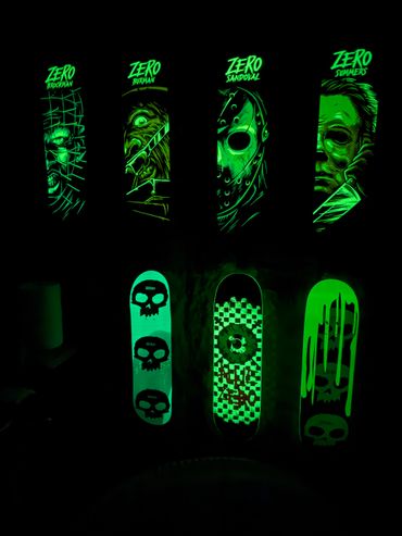 Glow-in-the-dark skateboard decks with horror character designs and skull graphics.