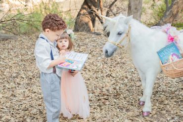 reading books with a white unicorn during a magical literacy event hosted by All God's Creatures