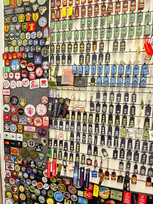 A collection of colorful military and police patches displayed on a wall.