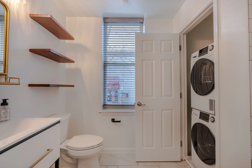 bathroom with stackable washer and condenser dryer