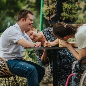 Three friends enjoying laughter and conversation outdoors.
