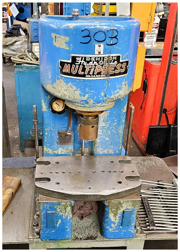 A blue Denison oil multipress machine in a workshop.