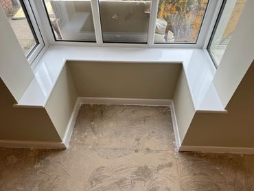 Freshly painted white window sill in a bay window area.