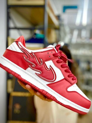 Red and white sneaker with a unique flame-style swoosh design.