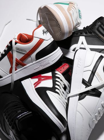 A collection of stylish Alphabet sneakers in various colors piled together.