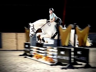 White horse jumping with girl.