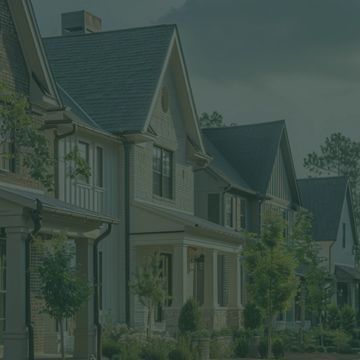A row of modern suburban houses with well-maintained yards.