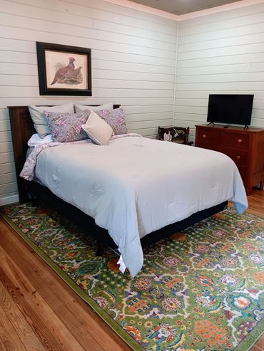 Bedroom 1 features a comfy queen size bed with an overhead ceiling fan light. There is plenty