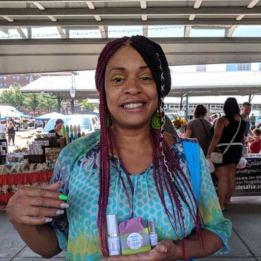 Happy customer holding propolis facial bar, retinol eye serum, and facial serum.