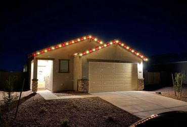 A house decorated with red and yellow Christmas lights at night.