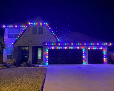 House decorated with colorful Christmas lights at night.