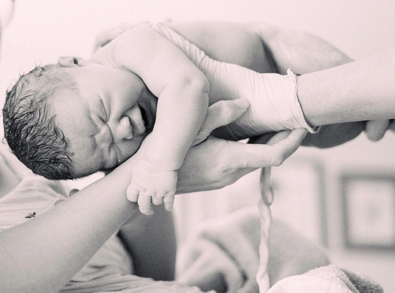 Newborn with midwife at homebirth