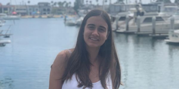 Photo of Daria, main tutor, against a marina background.