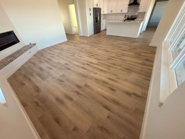 Spacious modern kitchen and living area with wood flooring.