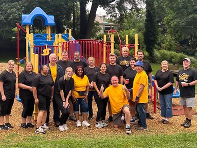 Dan Powell with a group of volunteers cleaning a playground in Rochester, NY