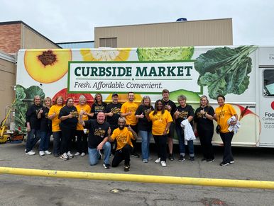 A group of volunteers posing for a picture in front of  a Food Link, Food Pantry delivery truck.