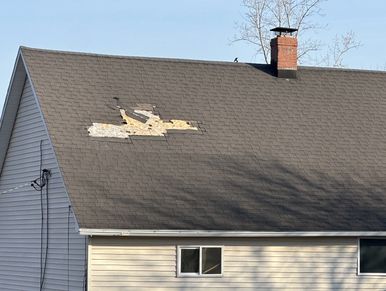 Roofing shingles missing, blown off a house observed during an emergency home watch visit.
