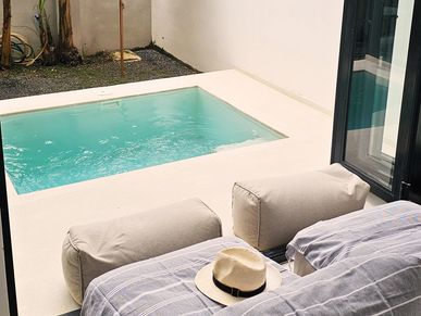 Cozy outdoor patio with a small plunge pool and banana trees at sunset.