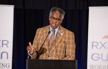 Man speaking at a conference on stage